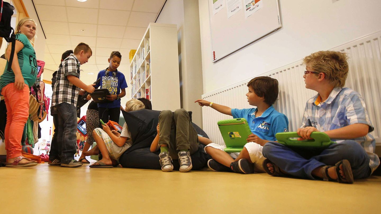Un grupo de niños se arremolina en el pasillo de un colegio. (EFE/Catrinus Van Der Veen)