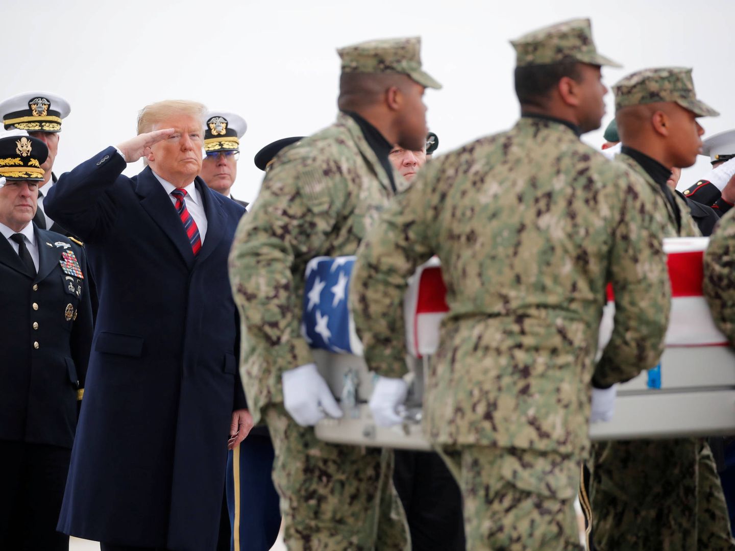 El presidente Trump junto a una guardia de honor que transporta el ataúd de Scott Wirtz y los otros tres estadounidenses caídos en Siria. (Reuters)