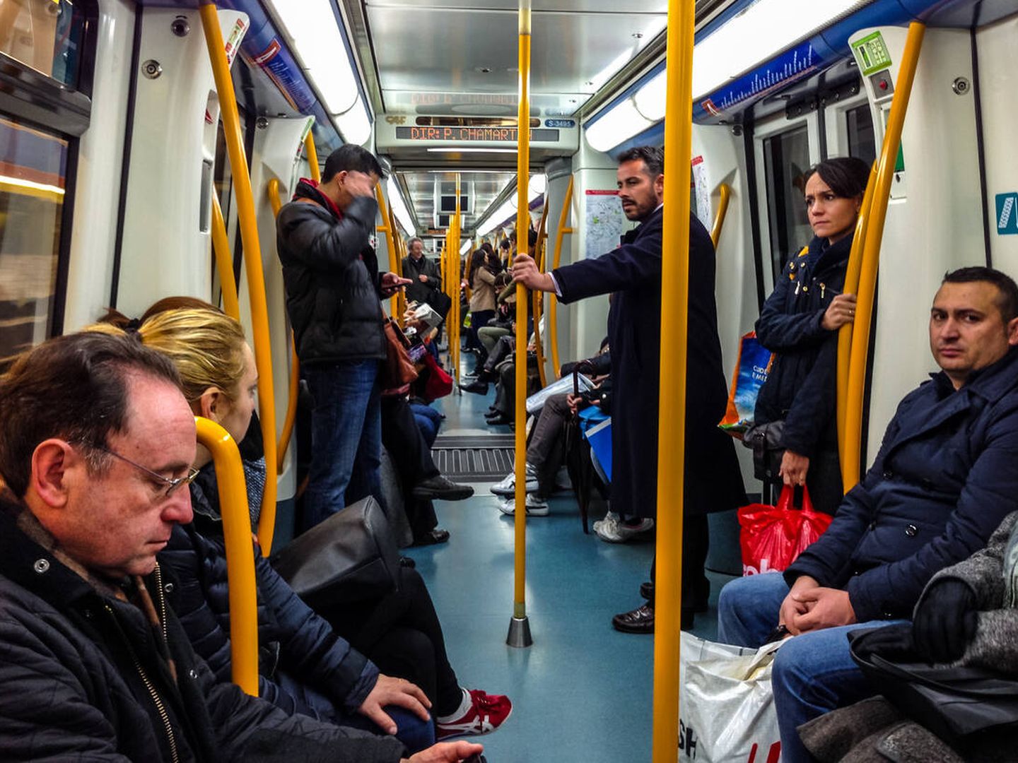 Personas sentadas en el metro de Madrid (iStock)