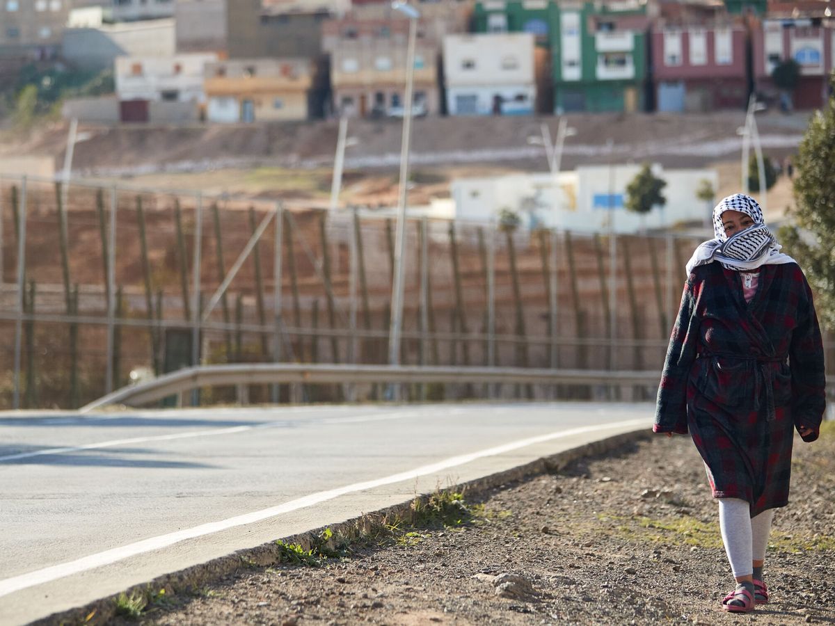 Foto: Una melillense pasea junto a la valla. (EFE/Miguel Osés)