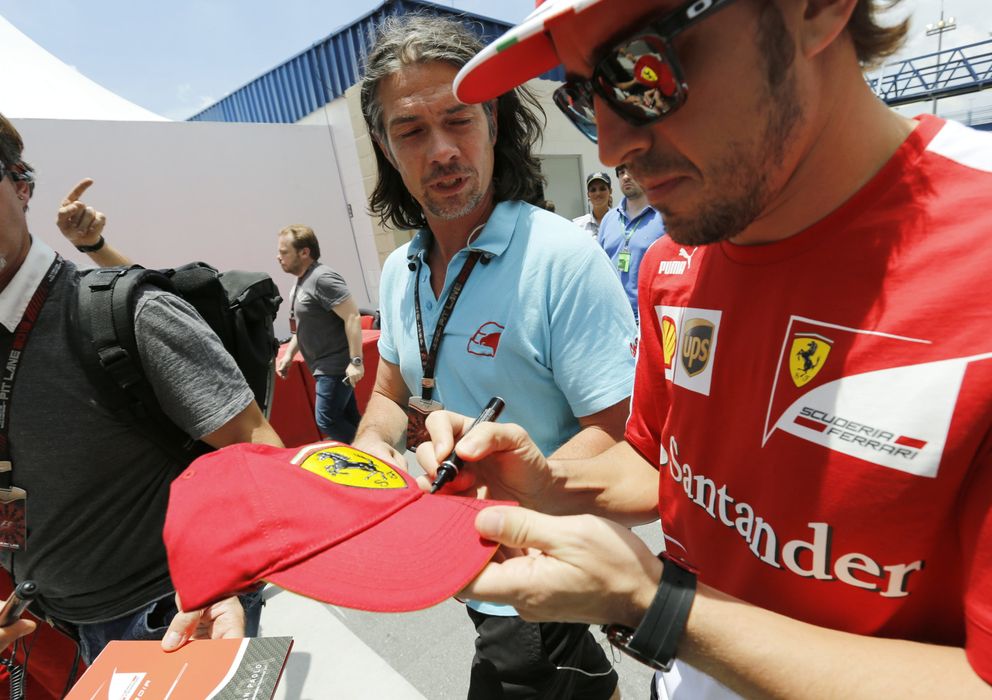Foto: Fernando Alonso firmando una gorra de la 'Scuderia'.