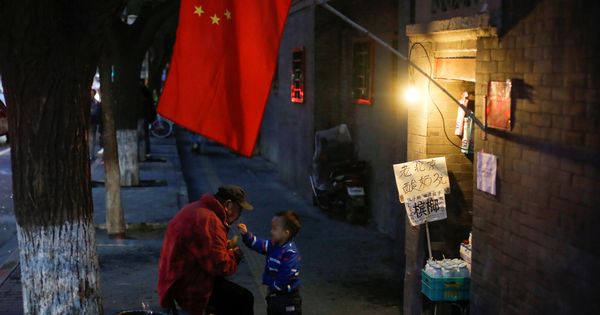 Foto: Un hombre juega con un niño en un callejón en la parte vieja de Pekín, en octubre de 2017. (Reuters)