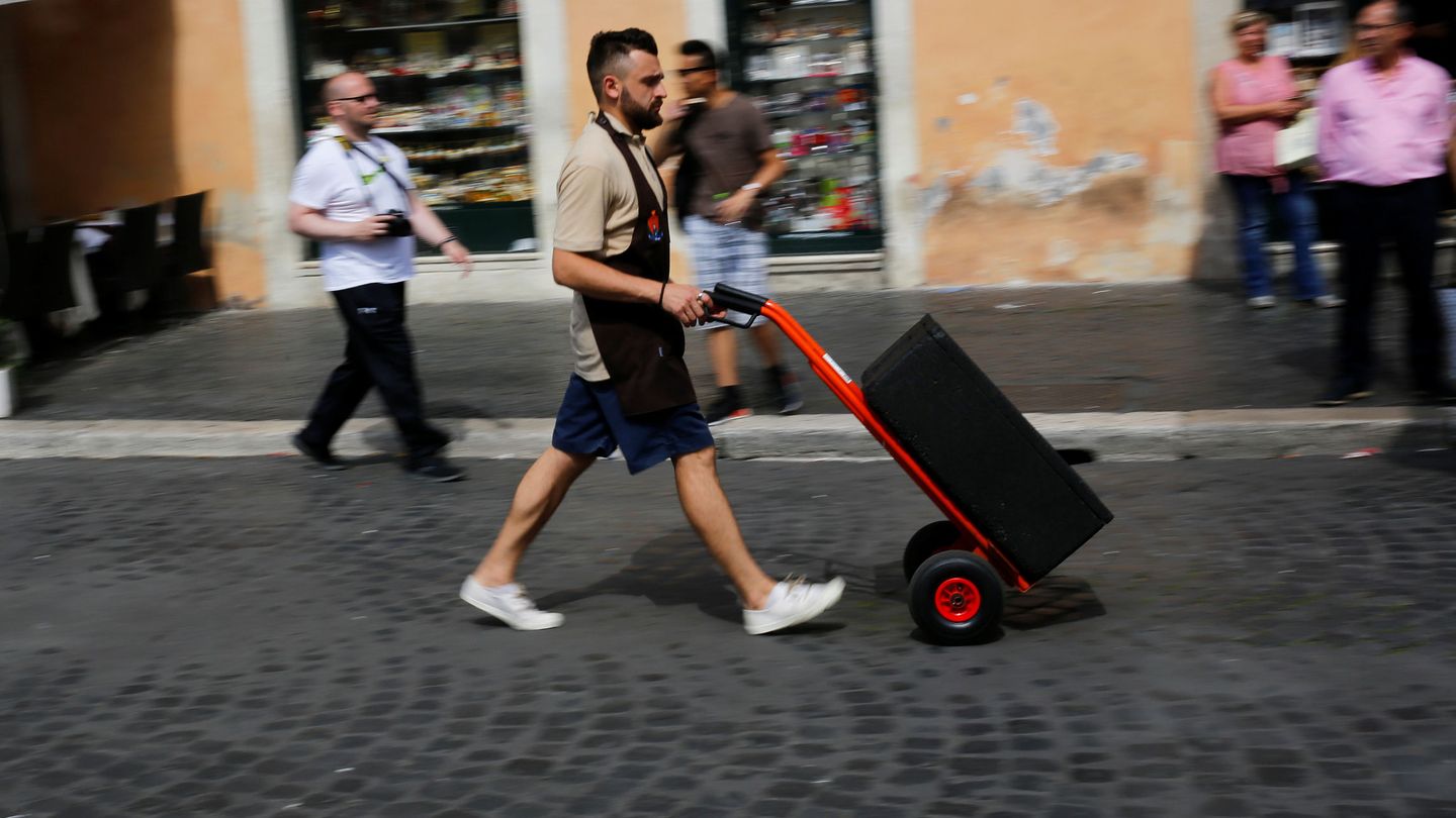 Un trabajador empuja un carrito en Roma, en junio de 2018. (Reuters)
