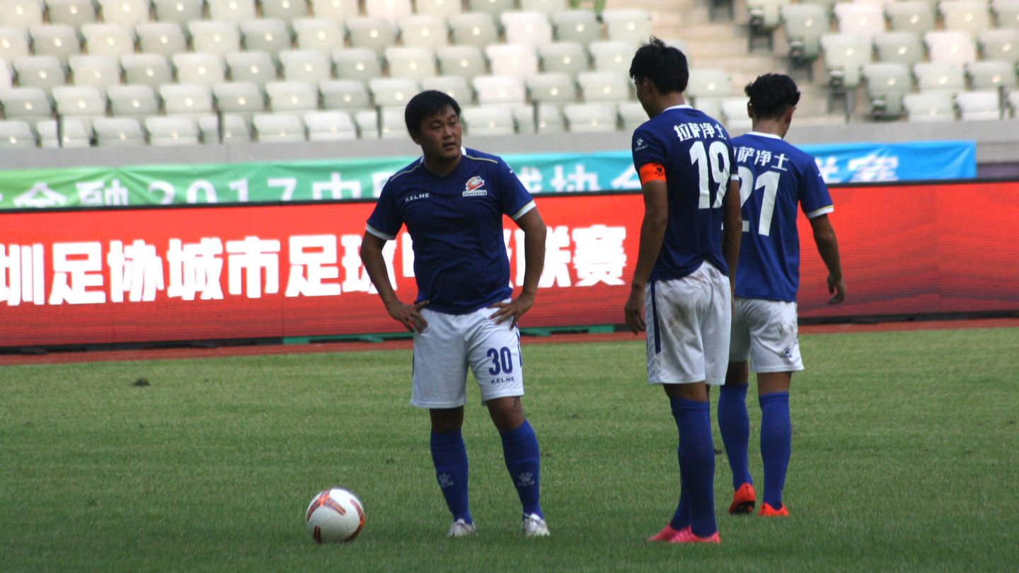 Varios jugadores del Lhasa FC hablan antes del lanzamiento de un penalti, durante un partido en Shenzen, el pasado septiembre. (J. Ibáñez)