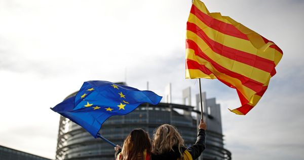 Foto: Una mujer sujeta una bandera europea y otra una catalana en una manifestación contra la independencia. (Reuters)