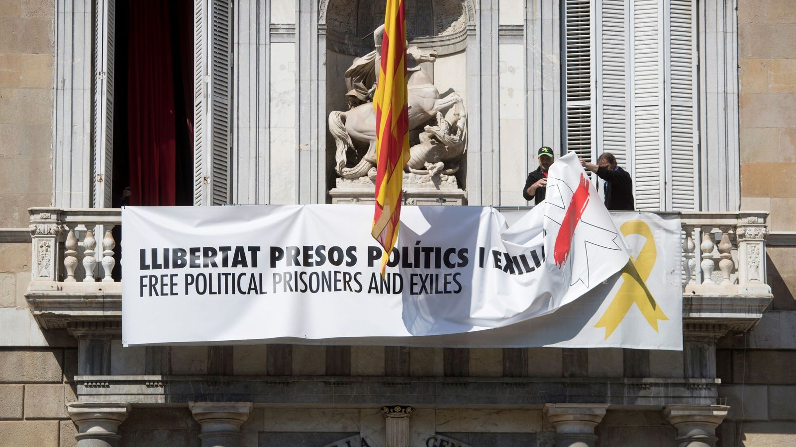 Foto: Momento de la retirada de la pancarta del Palau. (EFE)