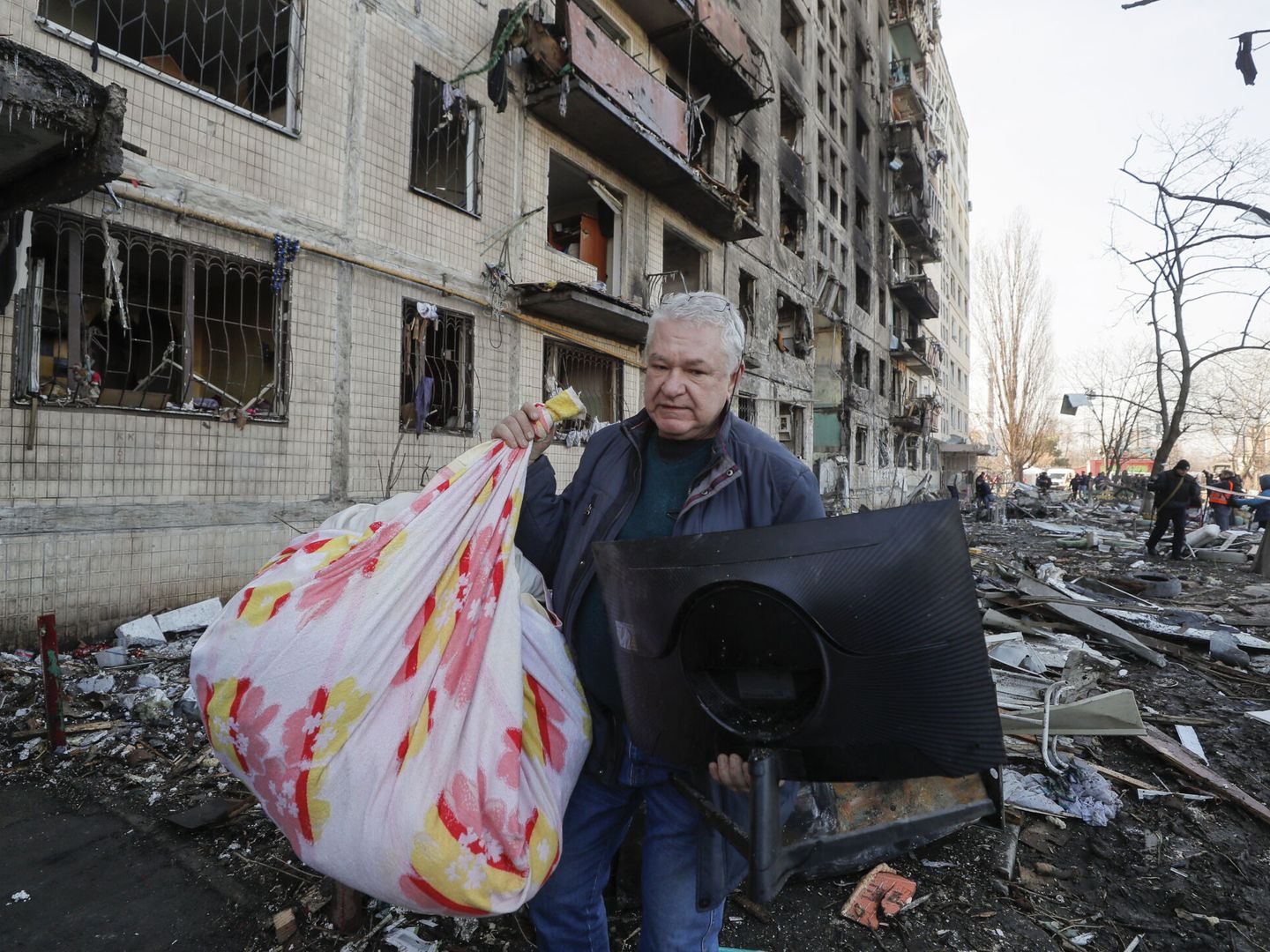 Un hombre acarrea sus pertenencias mientras abandona su casa destruida por los bombardeos rusos. (EFE/SERGEY DOLZHENKO)