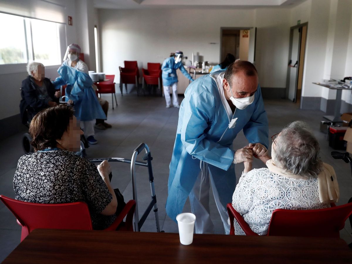 Foto: Un sanitario atiende a los ancianos alojados en la residencia Casablanca, en el barrio madrileño de Villaverde. (EFE)