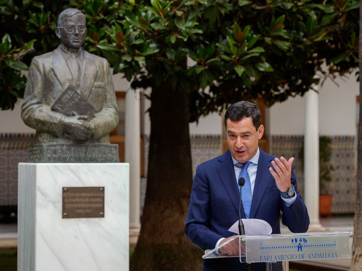 Foto: Juanma Moreno, junto al busto de Blas Infante que hay en el Parlamento andaluz. (EFE/Julio Muñoz)