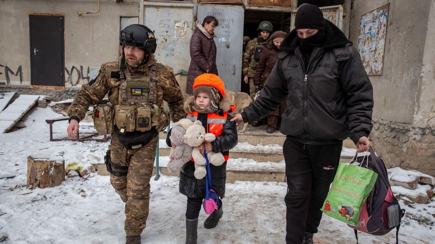 Policemen help Arina, 6, dressed in children's bulletproof vest and helmet during her evacuation from front line city of Bakhmut, amid Russia's attack on Ukraine, in Donetsk region, Ukraine January 31, 2023. REUTERS Oleksandr Ratushniak