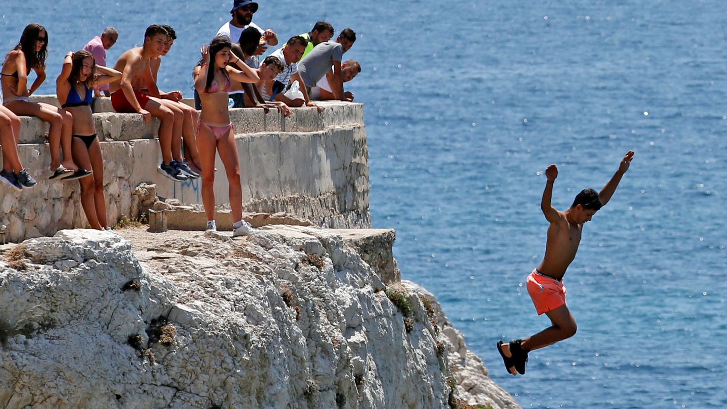 Adolescentes se lanzan al mar en Marsella. (Reuters)