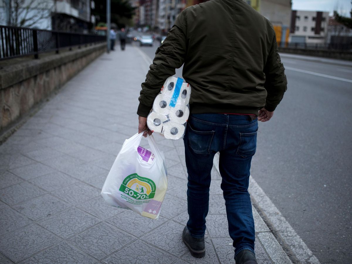 Foto: Un hombre con la bolsa de la compra y el inevitable papel higiénico. (EFE)
