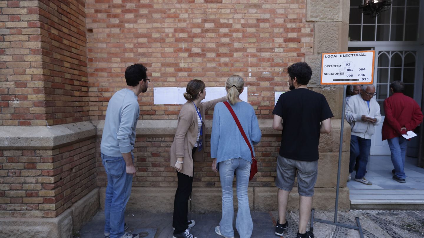 Varios votantes revisan el censo antes de acceder al colegio electoral. (EFE/Jorge Zapata)