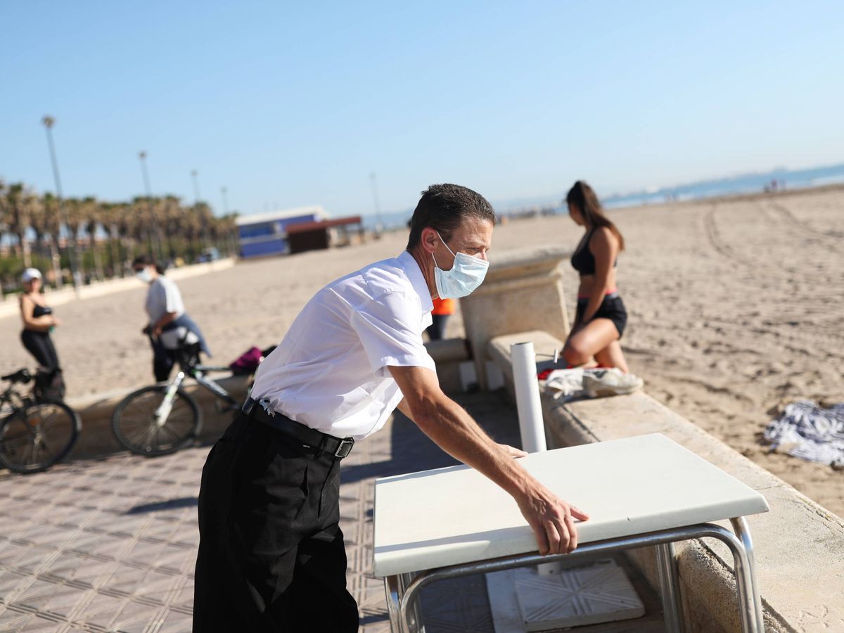 Foto: Un camarero, en la terraza de un restaurante, en la playa de la Malvarrosa. (Reuters)
