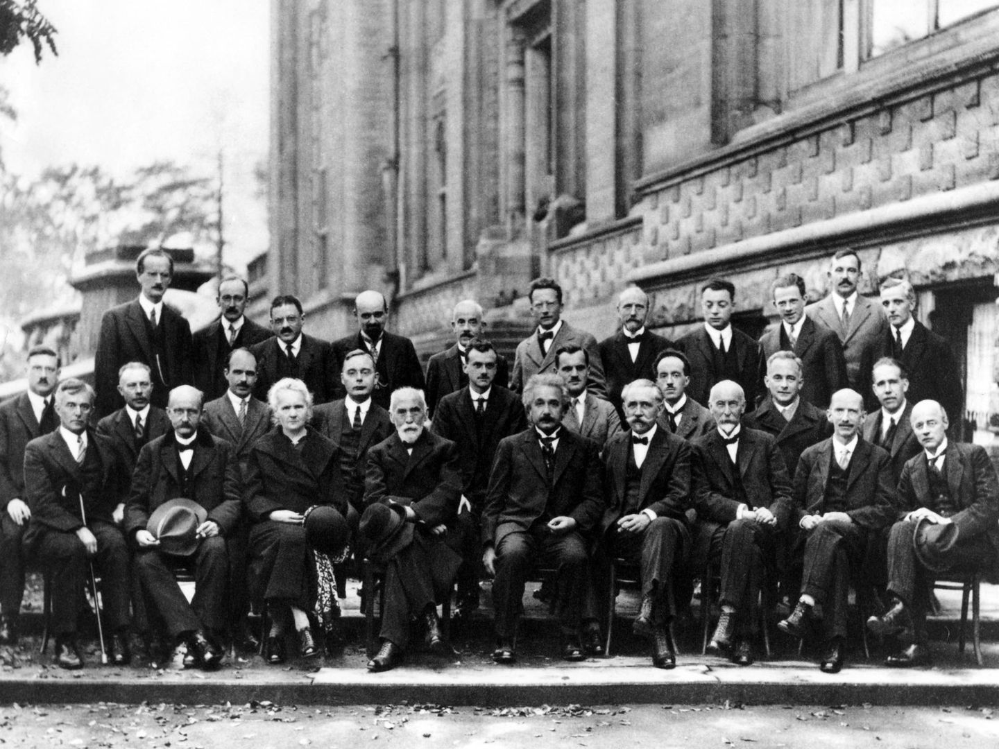 Planck (primera fila izquierda, sentado, calvo con bigote) Schrödinger (de pie, en medio con levita gris) y Einstein (primera fila, sentado en el centro) en la Conferencia de Solvay de 1927.