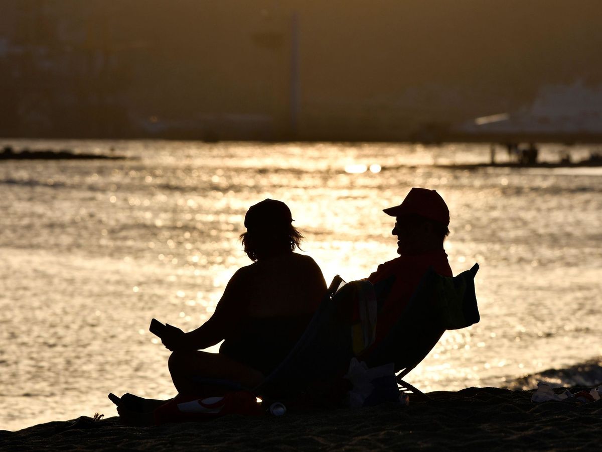 Foto: Dos personas descansan en una playa de Almería en una Noche de San Juan sin hogueras (EFE)