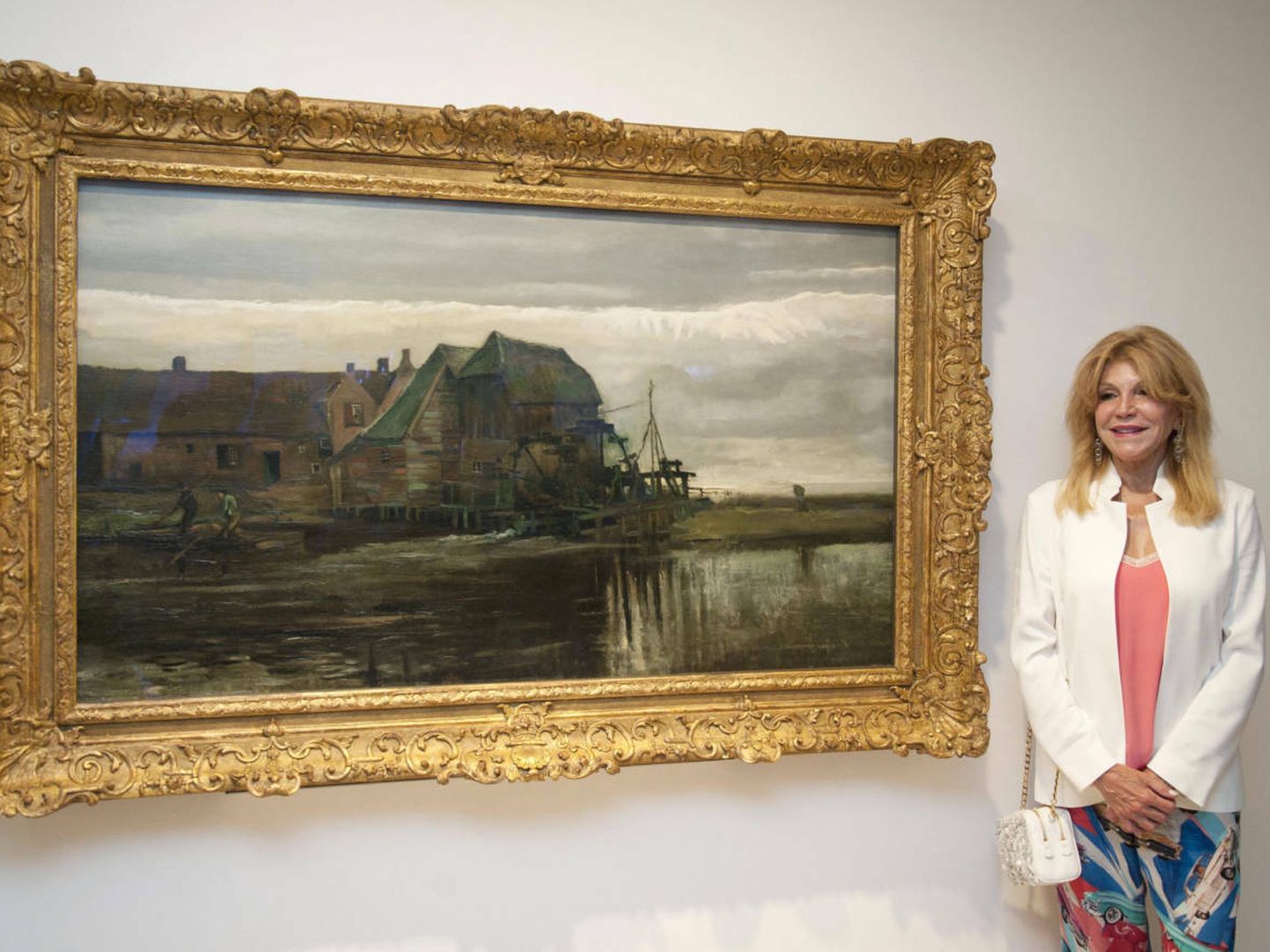 Carmen Thyssen posa junto a la obra 'Molino de agua en Gennep' de Vincent Van Gogh, de la muestra 'Un mundo ideal, de Van Gogh a Gauguin y Vasarely'. (EFE)