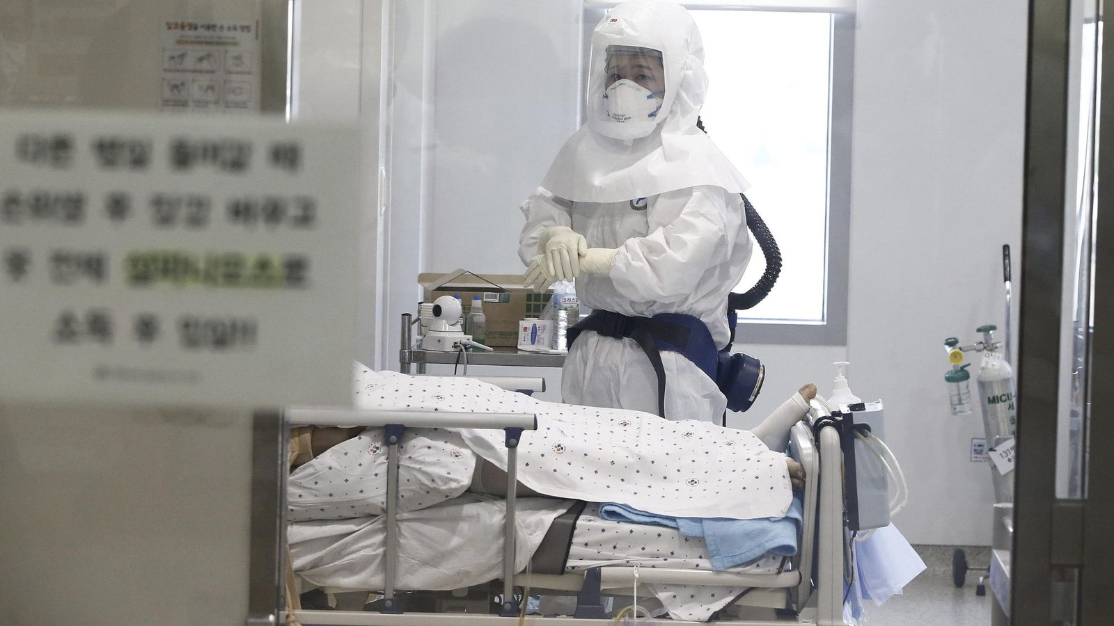 Foto: Un trabajador del servicio médico utiliza un traje protector mientras trata a un paciente con SROM en Seúl (EFE)