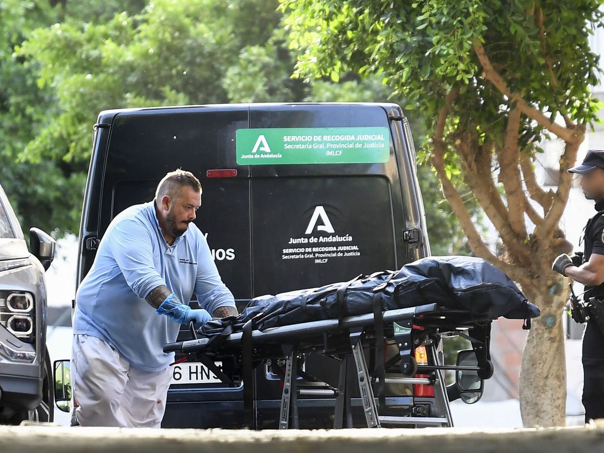 Foto: Miembros de servicios funerarios trasladan el cadáver. (EFE/Carlos Barba)