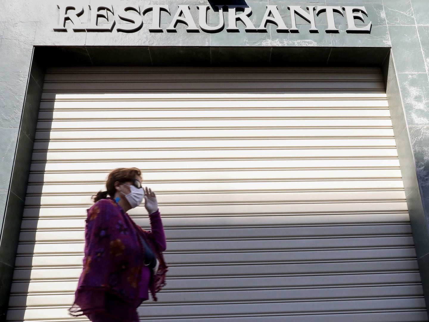 Una mujer pasa ante un restaurante cerrado. (EFE)