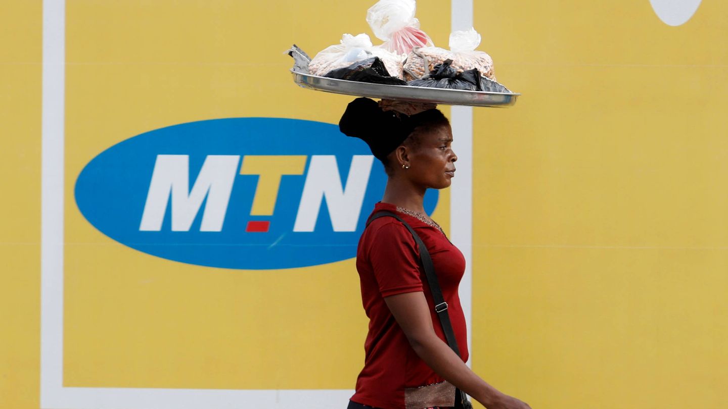 En Nigeria, una mujer pasa delante de un anuncio de la empresa de telecomunicaciones sudafricana MTN. (Reuters)
