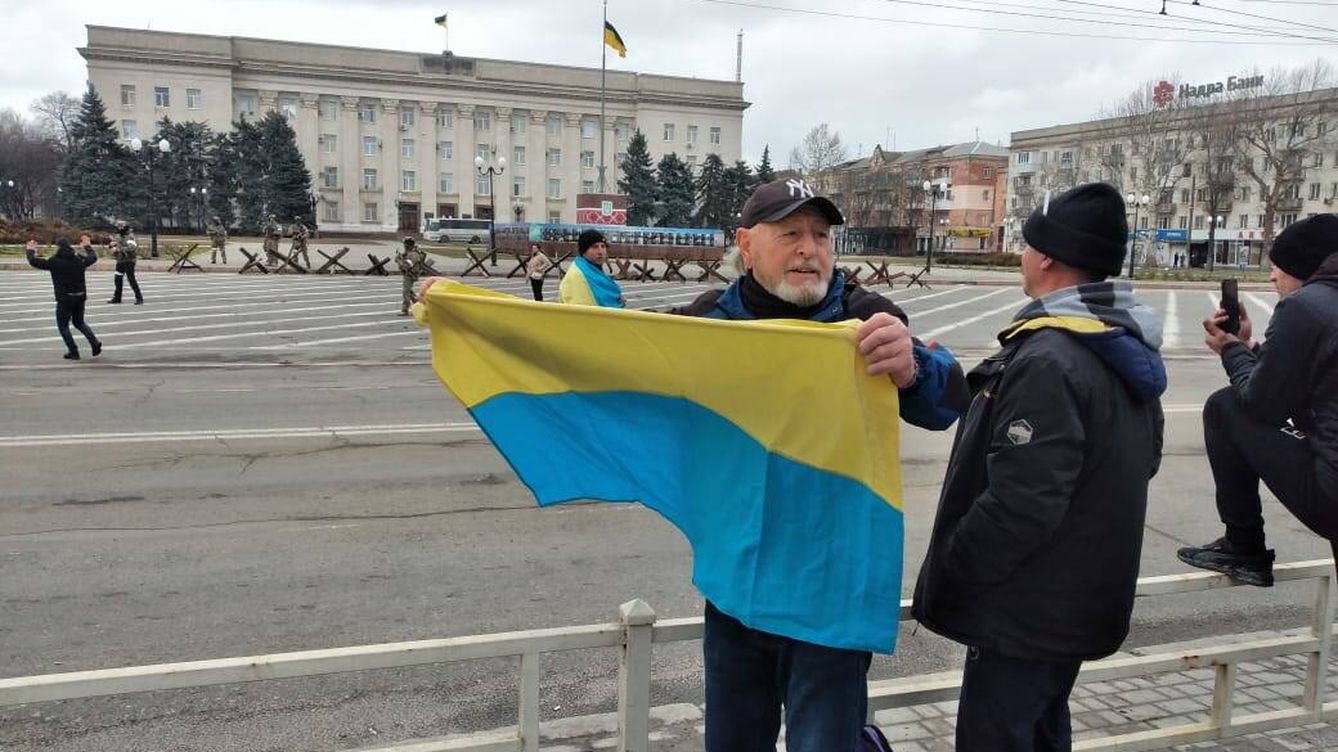 Foto: Mario García, protestando con una bandera ucraniana ante soldados rusos en Jersón. 
