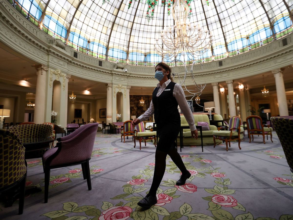 Foto: Una trabajadora camina bajo la cúpula acristalada del Hotel Westin Palace. (EFE)