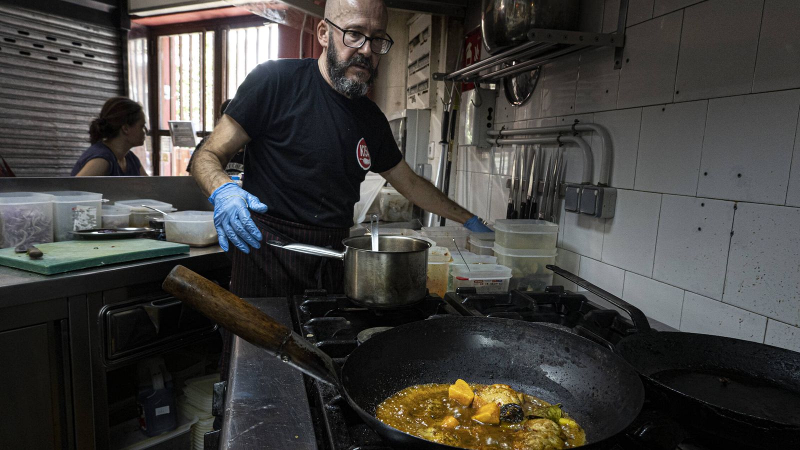Alejandro Zurdo cocina un curry de pollo con manzana y ciruelas pasas en el puesto de kitchen 154 en el Mercado de Vallehermoso. (Carmina Prieto)