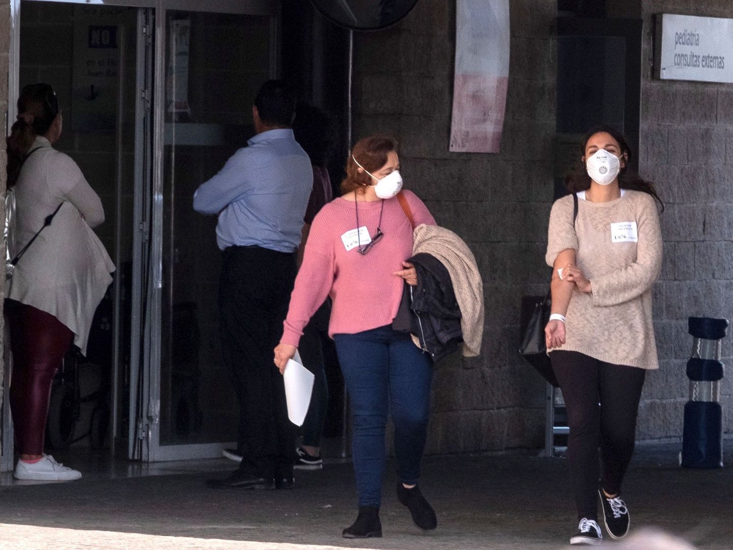 Dos pacientes salen de un centro de salud con mascarillas. (EFE)