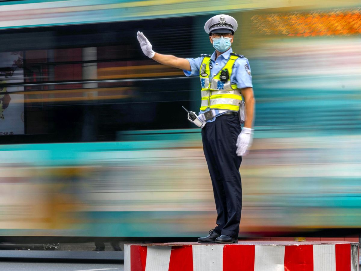 Foto: Un guardia regula el tráfico en una intersección en Guangzhou Cina. (EFE)