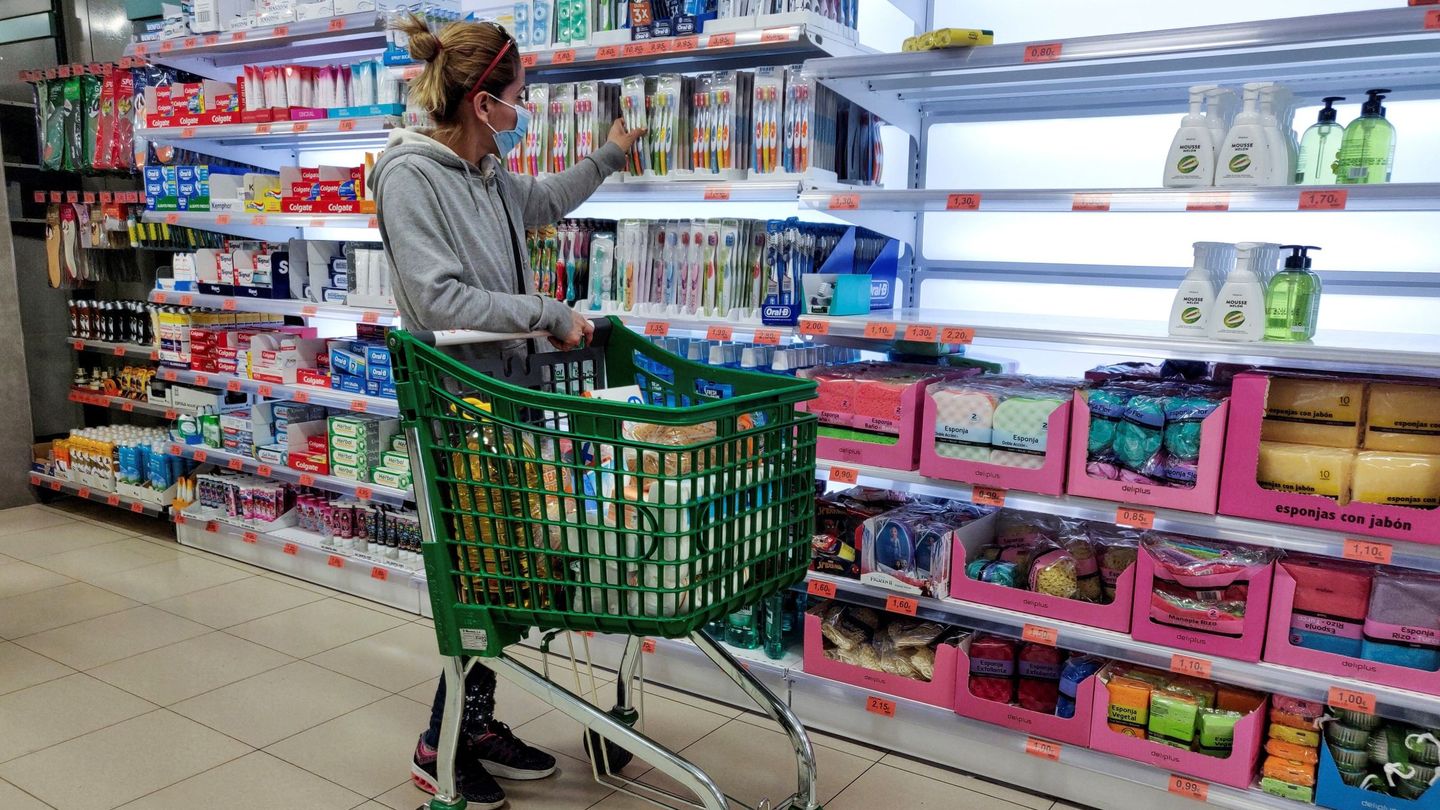 Una cliente con mascarilla observa estantes vacíos de jabón de manos en un supermercado de Madrid. (EFE)
