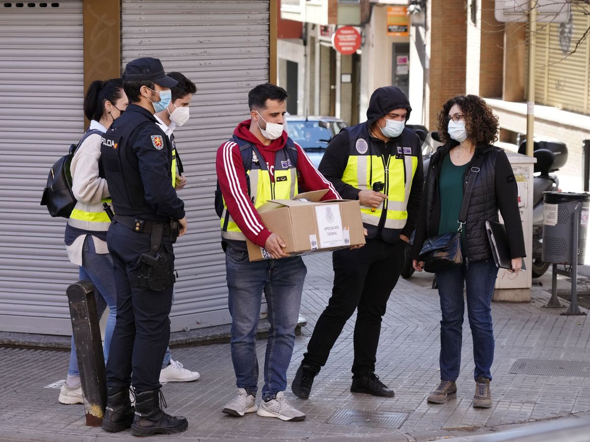 Foto: Agentes de la Policía Nacional portan material incautado del área de Cultura y Deportes del Ayuntamiento de Cornellà de Llobregat (Barcelona). (EFE/Enric Fontcuberta)