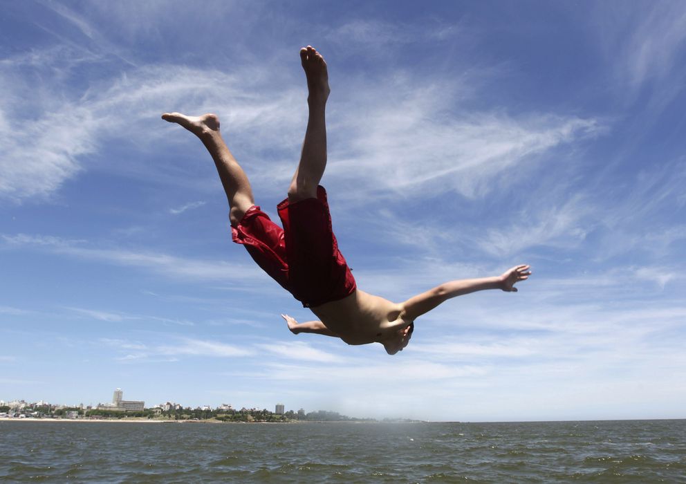 Foto: Un joven se arroja al Río de la Plata para refrescarse a su paso por la ciudad de Montevideo (Reuters).
