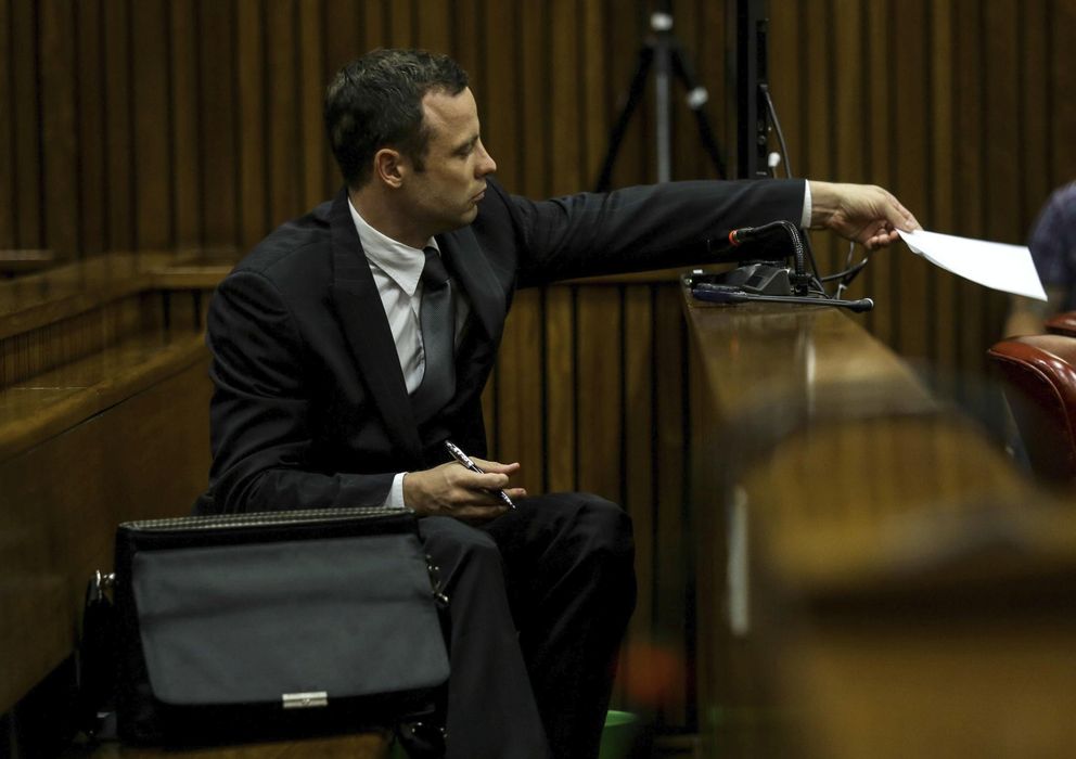 Foto: Pistorius pasa una nota a sus abogados desde el banquillo (Efe).