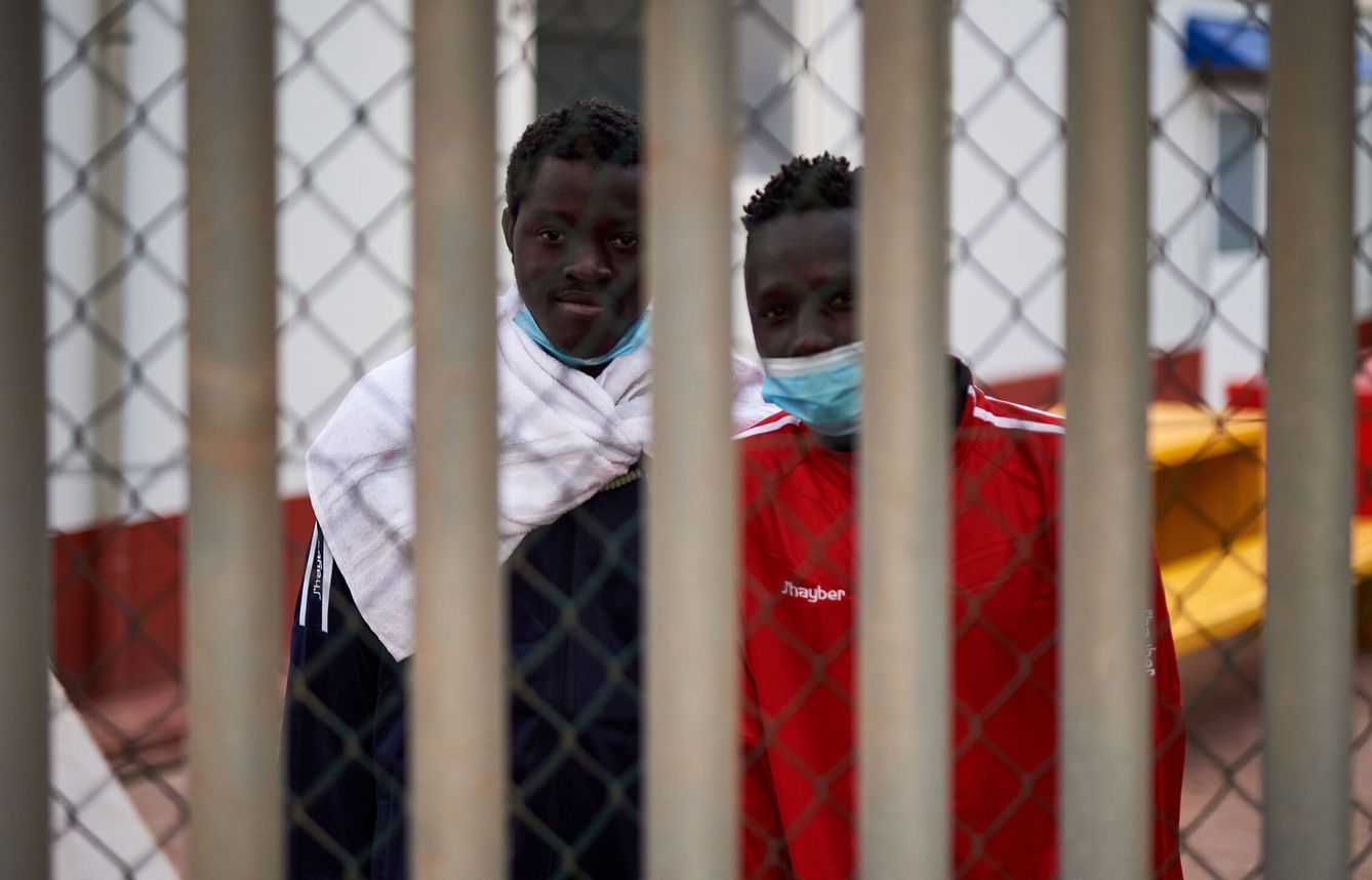 Dos inmigrantes detenidos en la valla de Melilla. (EFE)