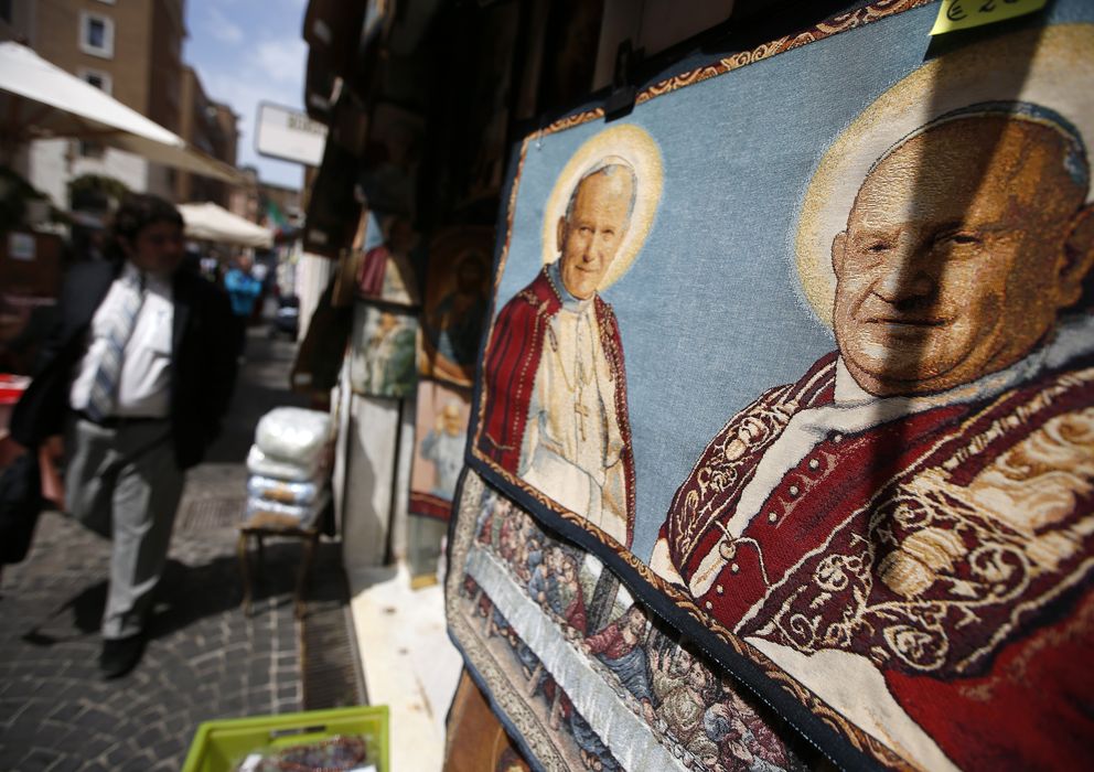Foto: Un tapiz muestra a los papas Juan XXIII y Juan Pablo II en una tienda de Roma, Italia (Reuters).
