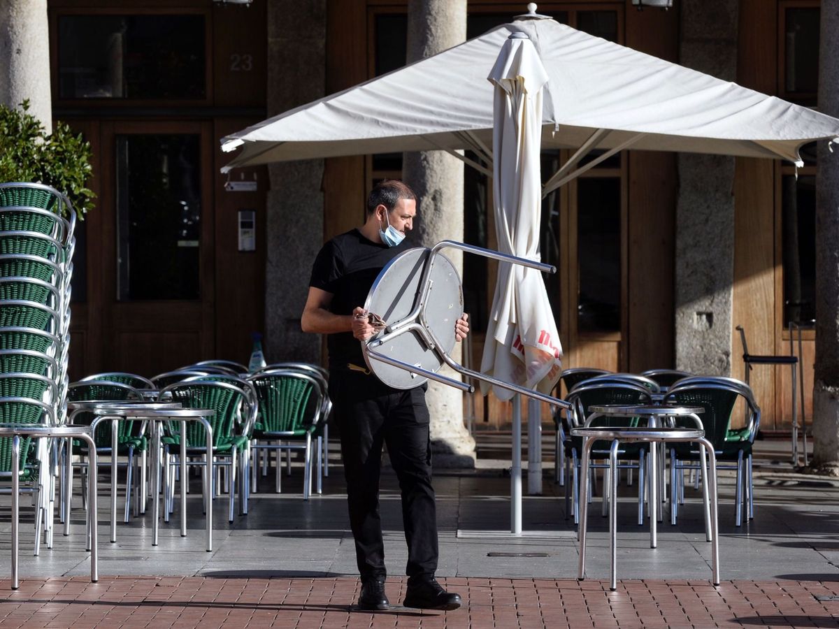 Foto: Un camarero coloca las mesas de una terraza. (EFE)