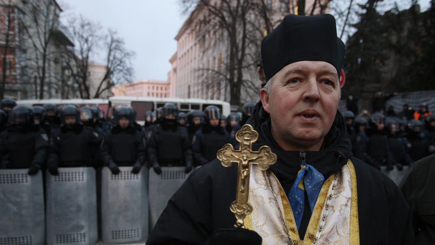 Un sacerdote ortodoxo ante los antidisturbios en Kiev (Reuters).