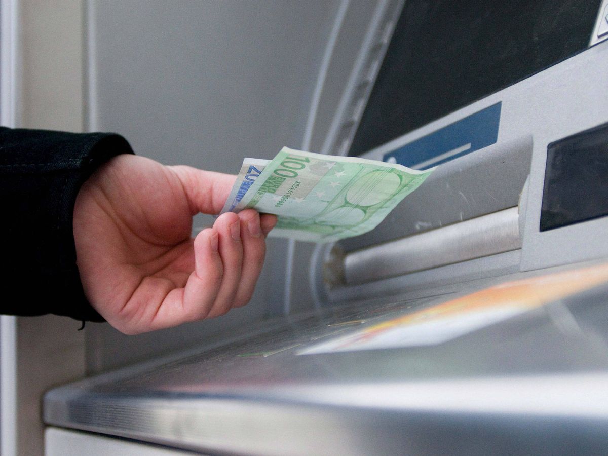 Foto: Persona retirando dinero del cajero. (EFE/Peter Hudec)