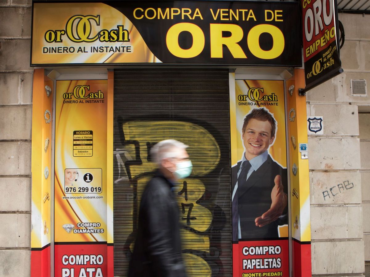 Foto: Un hombre pasa delante de un local de compra de Oro. (EFE)