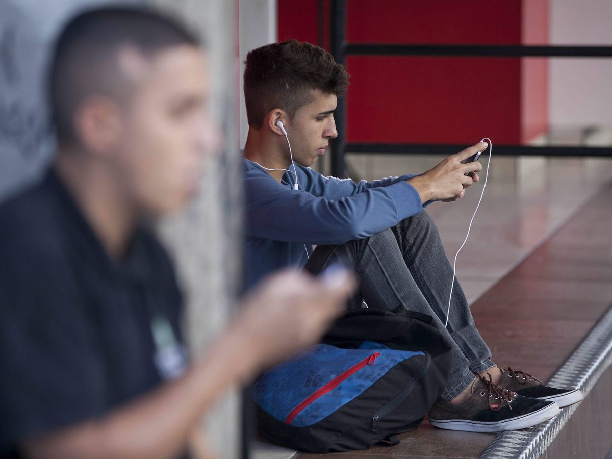 Foto: Jóvenes en la calle con sus teléfonos móviles. (EFE/Sebastião Moreira)