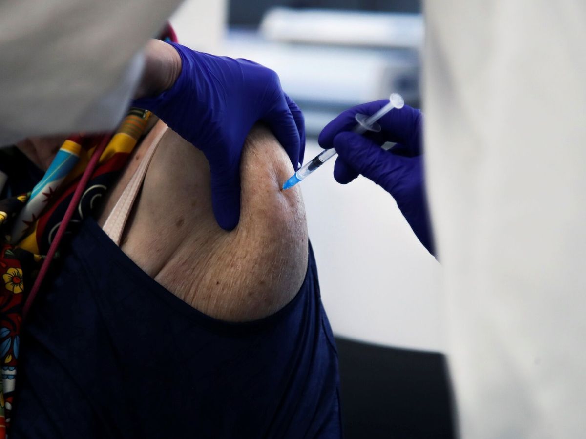Foto: Una mujer se vacuna de la gripe y el covid-19 en Madrid. (EFE/David Fernández)