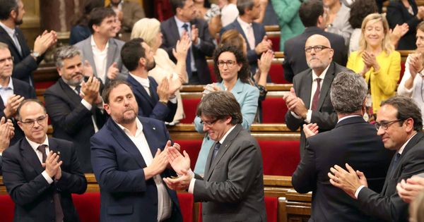 Foto: El presidente de la Generalitat, Carles Puigdemont (c), su Gobierno, y el resto de los diputados celebran la aprobación de la ley del referéndum. (EFE)