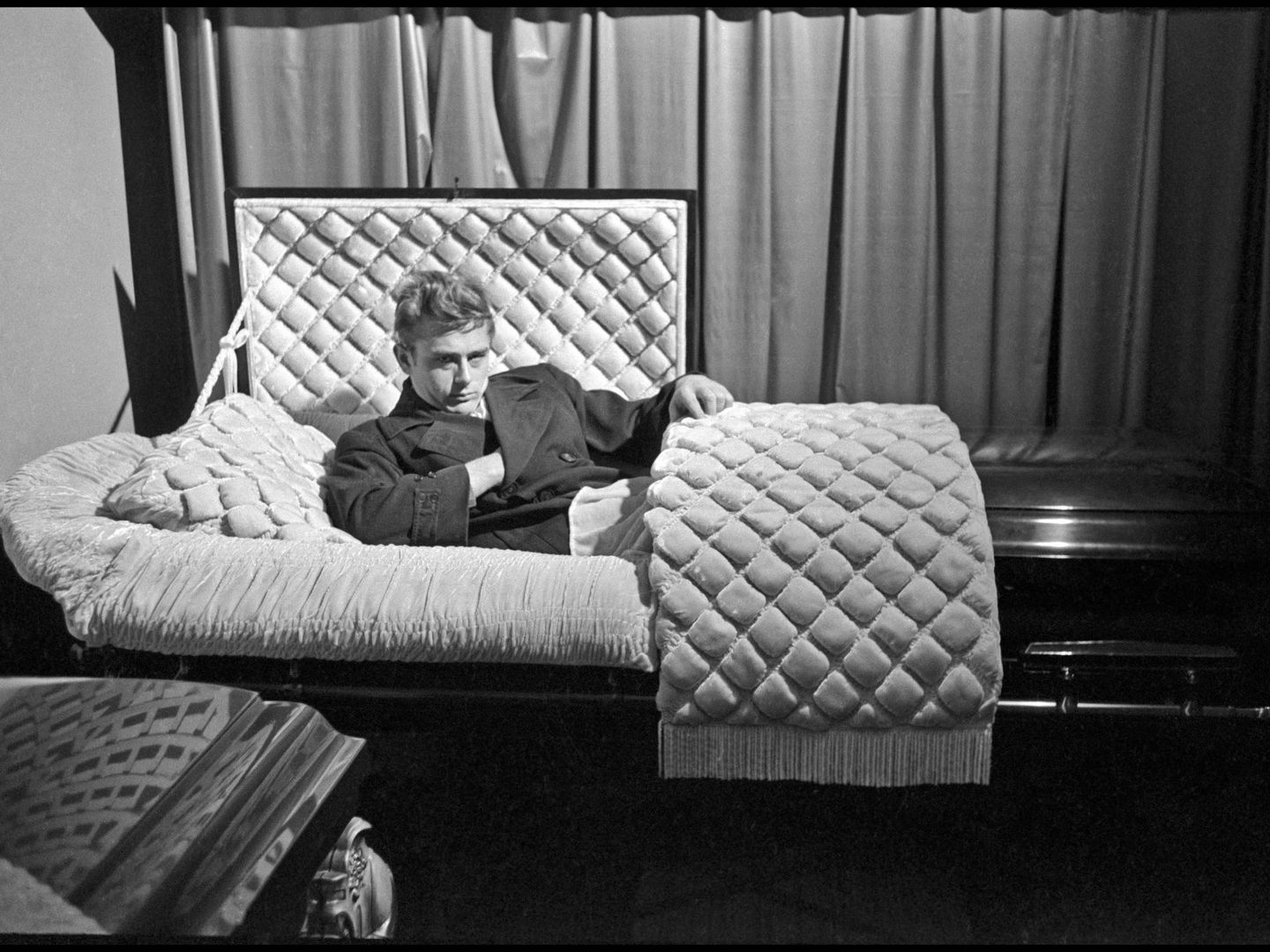James Dean posando en un ataúd en 1955, siete meses antes de morir. (CaixaForum)