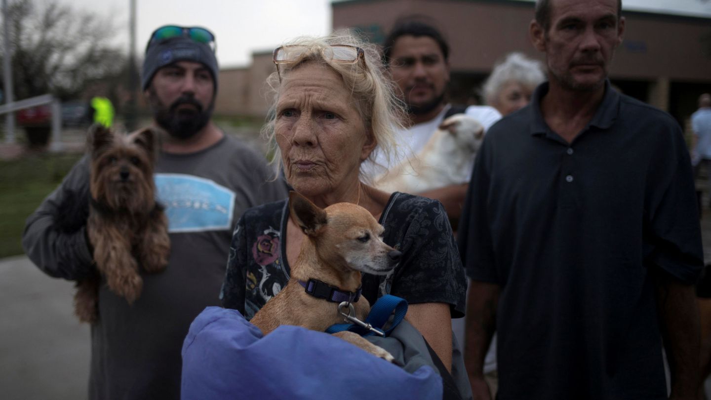 Julie, con su perro en brazos, espera a ser evacuada a Austin desde Rockport. (Reuters)