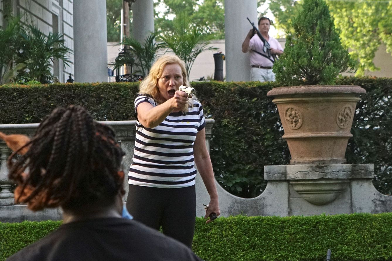 La mujer, apuntando con una pistola a los manifestantes que pasaban cerca de su mansión. (Reuters)