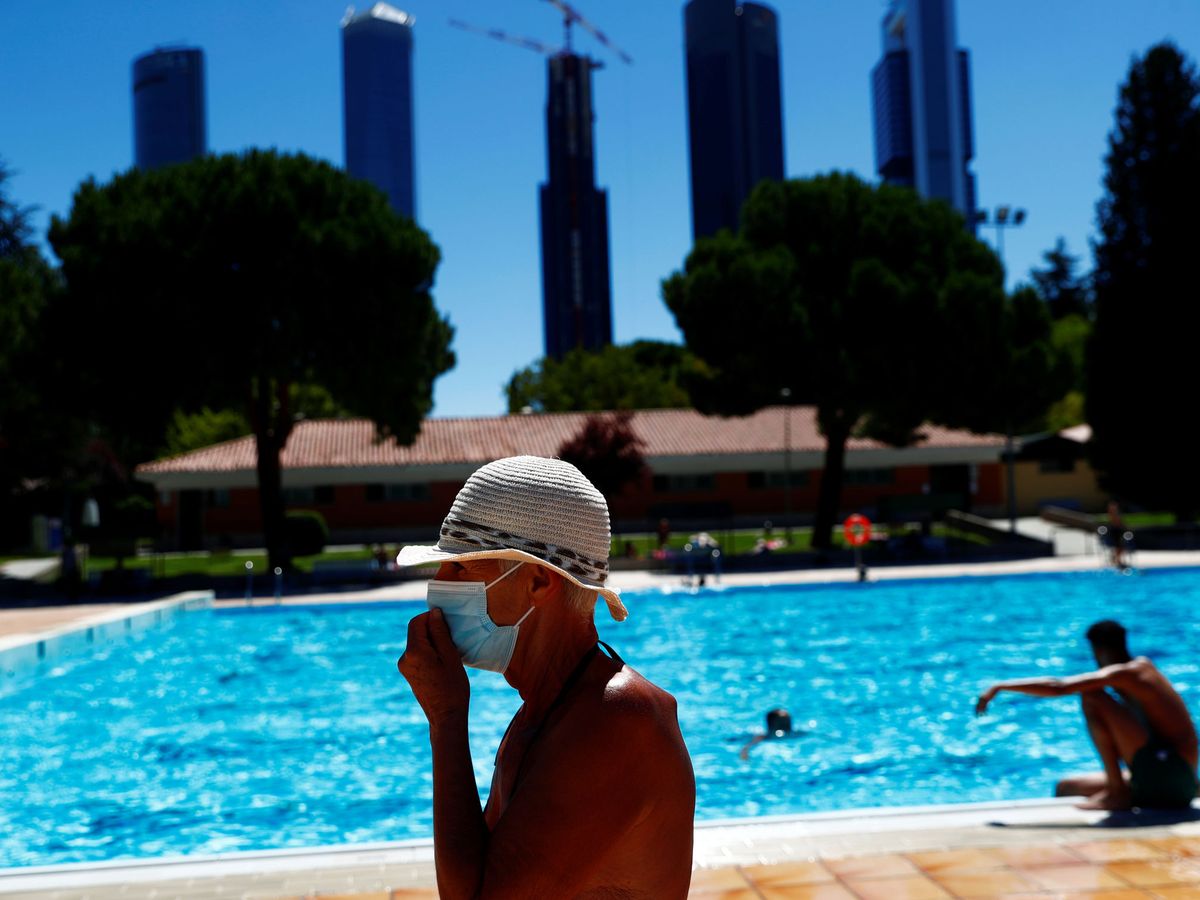 Foto: Una persona con mascarilla en una piscina de Madrid. (EFE)