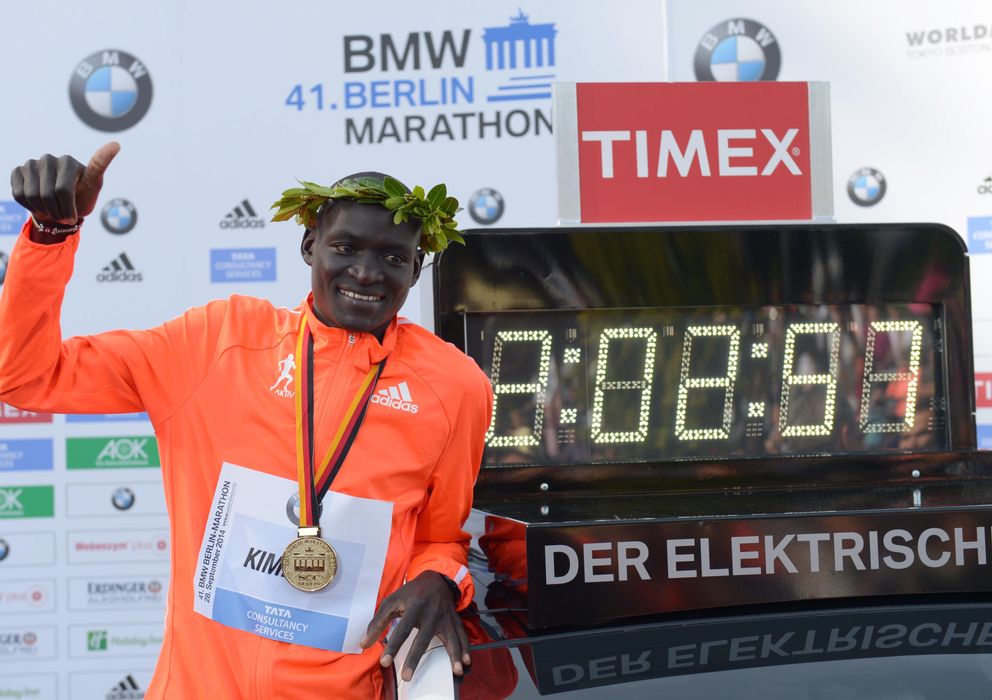Foto: Dennis Kimetto posa sonriente al lado del reloj que acredita el nuevo record del mundo de maratón.   