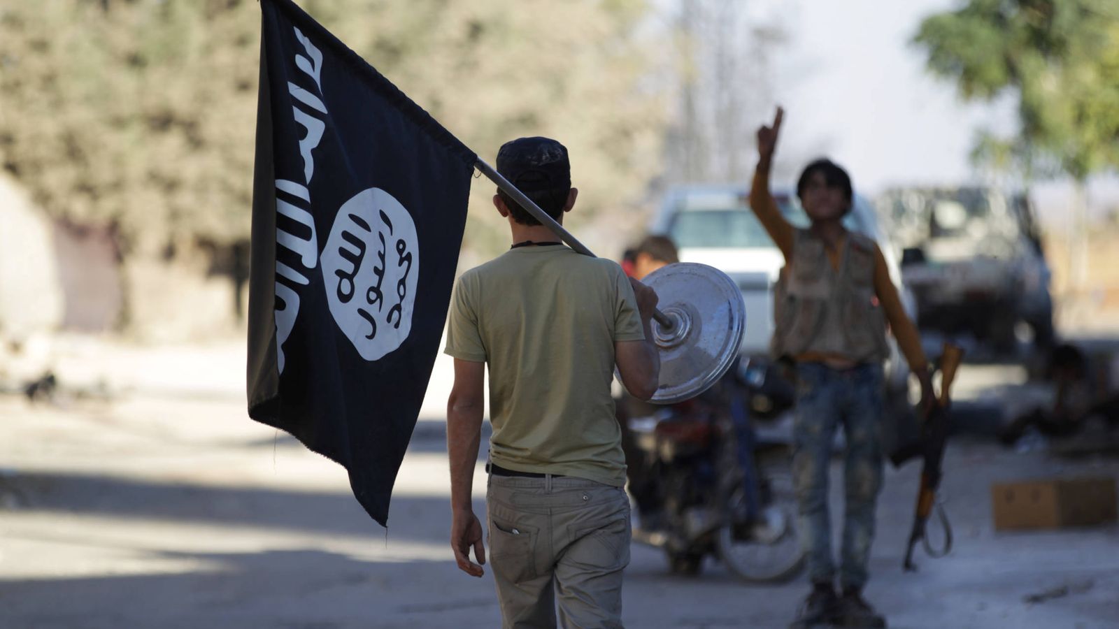 Foto: Un rebelde quita una bandera que pertenecía al Estado Islámico. (Reuters)