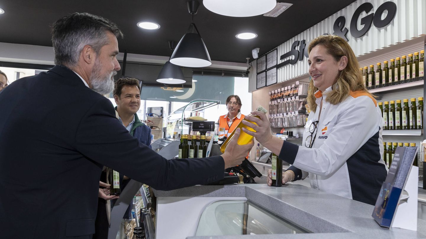 Valero Martín, director general del área cliente de Repsol, entrega una botella de aceite usado.